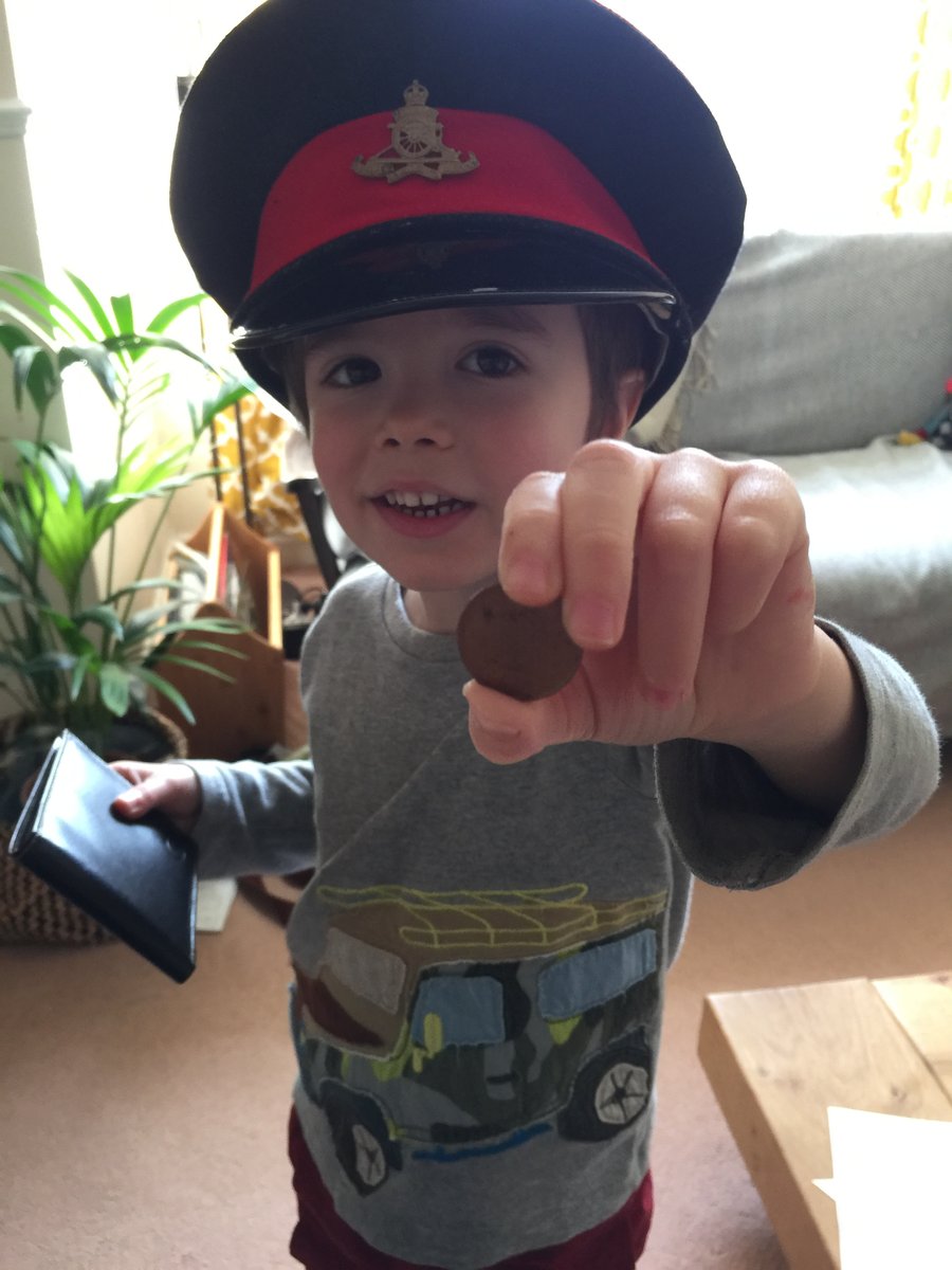 A child in an official-looking police hat holds up a badge, newly recruited as a special agent
